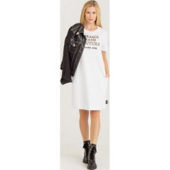 SUKIENKA VERSACE JEANS COUTURE. Białe sukienki Versace Jeans Couture, na co dzień, l, z aplikacjami, z bawełny, bez kołnierzyka, bez ramiączek, proste. Za 909.00 zł.