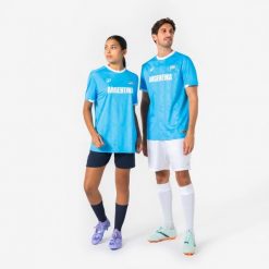 Koszulka piłkarska dla kibiców Argentyna 2026. Białe bluzki KIPSTA, s, bez wzorów, z materiału, sportowe, bez kołnierzyka, bez ramiączek. Za 44.99 zł.