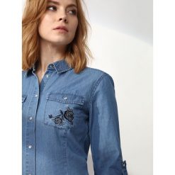 KOSZULA DŁUGI RĘKAW DAMSKA Z APLIKACJĄ. Niebieskie koszule TOP SECRET, z aplikacjami, z jeansu, bez kołnierzyka, bez ramiączek. W wyprzedaży za 49.99 zł.