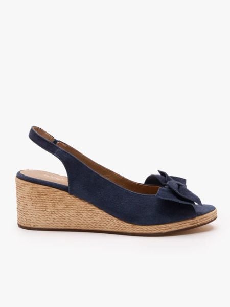 Granatowe sandały na koturnie z kokardą. Niebieskie sandały Ryłko, bez wzorów, ze skóry, klasyczne, z okrągłym noskiem, bez obcasa, na koturnie, bez zapięcia. Za 399.99 zł.