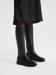 Eleganckie czarne kozaki z wąską cholewką. Czarne kozaki Ryłko, z gumy, z okrągłym noskiem, bez obcasa, na obcasie, bez zapięcia. Za 699.99 zł.