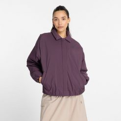Kurtka damska New Balance WJ43506PLN – fioletowa. Fioletowe kurtki sportowe New Balance, s, bez wzorów, z materiału, bez kaptura. Za 299.99 zł.