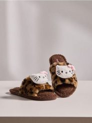 Otwarte kapcie z naszywką Hello Kitty - brązowy. Brązowe obuwie domowe Sinsay, z aplikacjami, z otwartym noskiem, bez zapięcia. Za 29.99 zł.