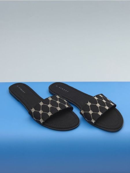 Klapki - czarny. Czarne klapki Sinsay, bez wzorów, bez obcasa, na płaskiej podeszwie. Za 39.99 zł.