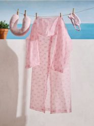 Płaszcz przeciwdeszczowy z motywem kokard - różowy. Czerwone płaszcze Sinsay, bez wzorów, bez kaptura. Za 9.99 zł.