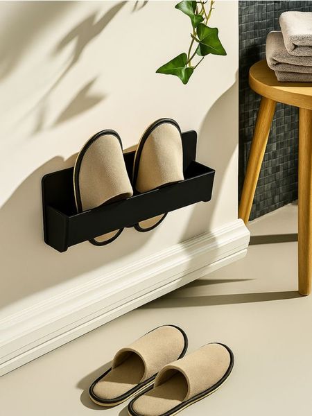 Ścienny uchwyt na kapcie - czarny. Czarne obuwie domowe Sinsay, bez wzorów, bez zapięcia. Za 10.99 zł.