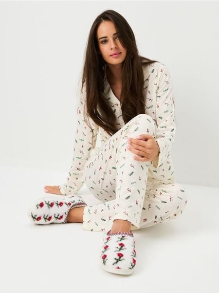 Ocieplane kapcie z kożuszkiem - kremowy. Białe obuwie domowe Sinsay, bez wzorów, bez zapięcia. Za 29.99 zł.