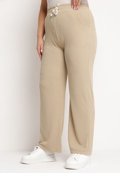 Beżowe Proste Szerokie Spodnie z Gumką w Pasie i Wysokim Stanem Trantia. Brązowe spodnie materiałowe Born2be, na co dzień, l, bez wzorów, z jeansu, z podwyższonym stanem. Za 69.99 zł.