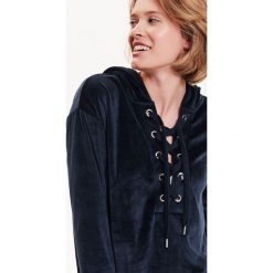BLUZA DAMSKA Z KAPTUREM I OZDOBNYM WIĄZANIEM, WELUROWA. Czerwone bluzy TROLL, na jesień, s, bez wzorów, z weluru, z kapturem. W wyprzedaży za 39.99 zł.