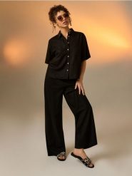 Klapki z motywem zebry ze skórzaną wkładką - czarny. Czarne klapki Sinsay, bez wzorów, bez obcasa. Za 49.99 zł.