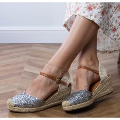 Srebrne sandały brokatowe na koturnie srebrny. Szare sandały bez wzorów, ze skóry ekologicznej, eleganckie, z okrągłym noskiem, bez obcasa, na koturnie, bez zapięcia. Za 96.19 zł.
