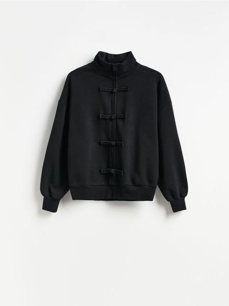 Bluza z ozdobnym zapięciem - czarny. Czarne bluzy Reserved, l, bez wzorów, z bawełny, bez kaptura. Za 139.99 zł.