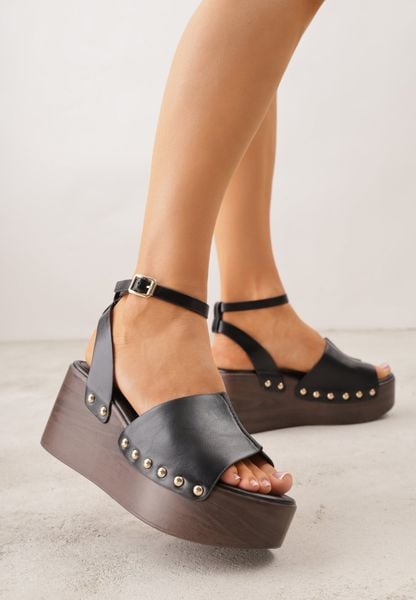 Czarne Sandały na Koturnie i Platformie Ozdobione Nitami Rhethe. Czarne sandały Born2be, bez wzorów, z jeansu, eleganckie, bez obcasa, na koturnie, bez zapięcia. Za 99.99 zł.