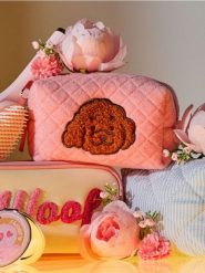 Pikowana kosmetyczka z naszywką w kształcie psa - różowy. Czerwone kufry i kosmetyczki Sinsay, z aplikacjami, pikowane, bez dodatków. Za 12.99 zł.