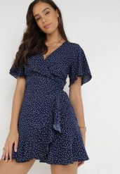 Granatowa Sukienka Devizo. Niebieskie sukienki Born2be, s, bez wzorów, z materiału, bez kołnierzyka, bez ramiączek, mini, kopertowe. Za 29.99 zł.