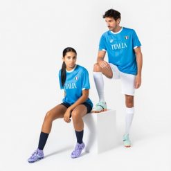 Koszulka piłkarska Włochy 2026 dla kibiców. Białe bluzki KIPSTA, s, bez wzorów, z materiału, sportowe, bez kołnierzyka, bez ramiączek. Za 44.99 zł.