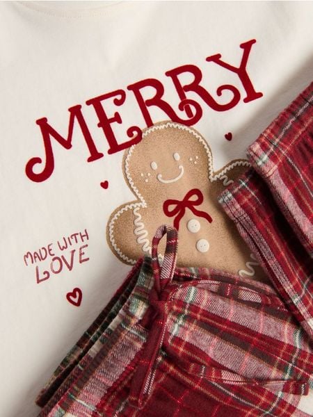 Piżama ze świątecznym motywem - czerwony. Czerwone piżamy Reserved, bez wzorów, z bawełny, bez ramiączek. W wyprzedaży za 49.99 zł.