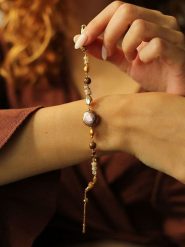 Pierres delicates Pozłacana bransoletka z kamieniami szlachetnymi i perłami rozmiar: onesize. Brązowe bransoletki Pierres delicates, z perłą, pozłacane. Za 52.99 zł.