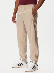 Adidas Spodnie dresowe Firebird KS7503 Beżowy Regular Fit. Brązowe spodnie dresowe Adidas, m, bez wzorów, z dresówki. Za 299.99 zł.