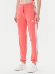 Adidas Spodnie dresowe Essentials 3-Stripes KE4387 Koralowy Regular Fit. Pomarańczowe spodnie dresowe Adidas, xs, bez wzorów, z bawełny. Za 219.99 zł.