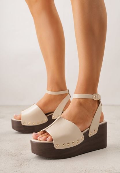 Beżowe Sandały na Koturnie i Platformie Ozdobione Nitami Rhethe. Brązowe sandały Born2be, bez wzorów, z jeansu, eleganckie, bez obcasa, na koturnie, bez zapięcia. Za 99.99 zł.