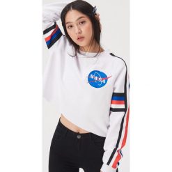 Krótka bluza z motywem NASA - Biały. Białe bluzy Sinsay, l, bez wzorów, bez kaptura. Za 49.99 zł.