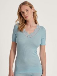 Calida Wełniana koszulka w kolorze błękitnym rozmiar: XS. Niebieskie bluzki Calida, xs, bez wzorów, z koronki, bez kołnierzyka, bez ramiączek. Za 148.26 zł.