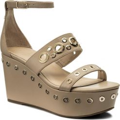 Sandały GUESS - Niomi FLNIO1 ELE03 CAMEL. Brązowe sandały Guess, z aplikacjami, z materiału, bez obcasa, na obcasie, bez zapięcia. W wyprzedaży za 329.00 zł.