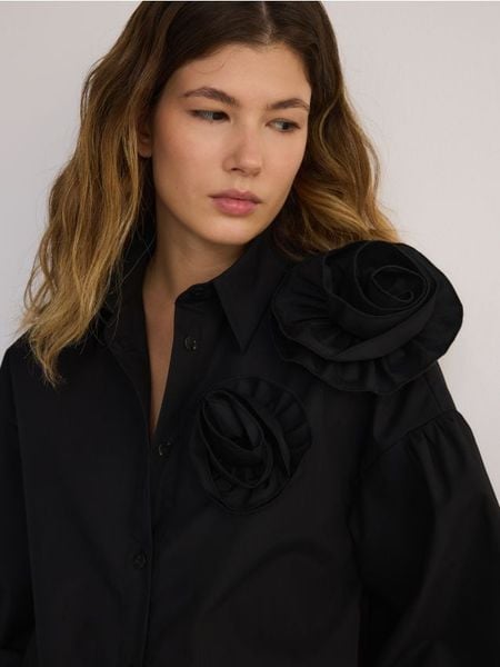 Koszula z ozdobnym kwiatem - czarny. Czarne koszule Reserved, l, bez wzorów, z bawełny, bez kołnierzyka, bez ramiączek. W wyprzedaży za 119.99 zł.