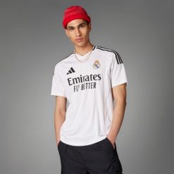 Koszulka piłkarska ADIDAS Real Madryt domowa sezon 24/25. Bluzki Adidas, xl, bez wzorów, eleganckie, bez kołnierzyka, bez ramiączek. W wyprzedaży za 279.99 zł.