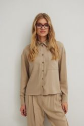 Koszula o prostym kroju z kieszonką w kolorze STONE BEIGE - ROMA. Brązowe koszule Marsala, m, bez wzorów, z tkaniny, eleganckie, bez kołnierzyka, bez ramiączek. Za 299.90 zł.