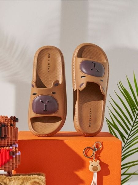 Piankowe klapki z motywem kapibary - beżowy. Brązowe klapki Sinsay, bez wzorów, bez obcasa. Za 29.99 zł.