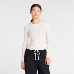 Koszulka damska New Balance WT53133PEF – beżowa. Brązowe bluzki New Balance, m, bez wzorów, z lyocellu, eleganckie, bez kołnierzyka, bez ramiączek. Za 199.99 zł.