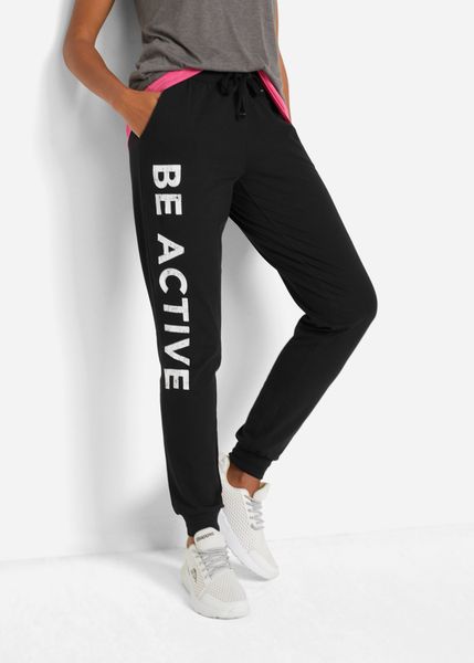 Spodnie sportowe bawełniane z nadrukiem, Loose Fit. Czarne spodnie dresowe bonprix, bez wzorów, z bawełny. Za 92.99 zł.