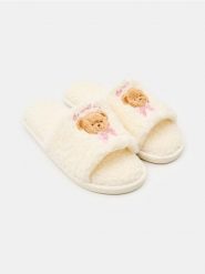 Kapcie z motywem misia i wykończeniem teddy - kremowy. Białe obuwie domowe Sinsay, bez wzorów, bez zapięcia. Za 25.99 zł.