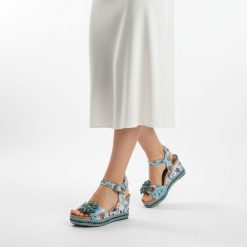 Sandały damskie Laura Vita, ze skóry naturalnej z kwiatowym nadrukiem i ozdobną aplikacją na pasku z przodu, niebieskie, 75 AC1198-75. Niebieskie sandały Laura Vita, z aplikacjami, ze skóry, bez obcasa, na koturnie, bez zapięcia. Za 349.00 zł.