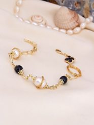 L'Atelier de Gaia Pozłacana bransoletka z onyksem i perłami rozmiar: onesize. Białe bransoletki L'Atelier de Gaia, z onyksem, pozłacane. Za 69.99 zł.