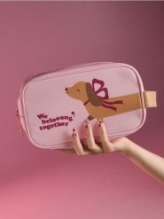 Kosmetyczka z motywem jamnika - różowy. Czerwone kufry i kosmetyczki Sinsay, bez wzorów, bez dodatków. Za 19.99 zł.