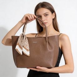 Torebka damska Rieker, ze skóry ekologicznej o prostej eleganckiej formie z ozdobną apaszką przy uchwycie wygodna do noszenia w dłoni i na ramieniu,. Brązowe shopper Rieker, bez wzorów, ze skóry ekologicznej, biznesowe, na ramię, bez dodatków. Za 279.00 zł.