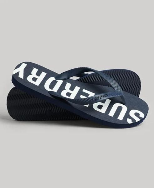 Superdry Code Core Sport Klapki gumowe – Eclipse Navy/Optic. Niebieskie klapki Superdry, bez wzorów, z gumy, bez obcasa. Za 116.60 zł.