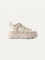 UGG Skórzane sandały "Cora" w kolorze kremowym rozmiar: 38. Brązowe sandały UGG, bez wzorów, z materiału, z otwartym noskiem, bez obcasa, na koturnie, bez zapięcia. Za 552.56 zł.
