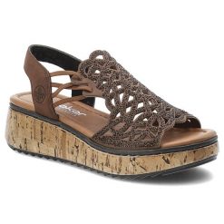 Sandały damskie Rieker, cholewka ze skóry ekologicznej ażurowa konstrukcja ozdobne zdobienia z drobnymi nitami, brązowe, V1765-24. Brązowe sandały Rieker, z aplikacjami, ze skóry ekologicznej, bez obcasa, na koturnie, bez zapięcia. Za 349.00 zł.