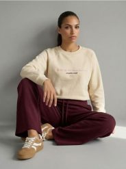 Bluza crewneck z haftowanym napisem NYC - kremowy. Białe bluzy Sinsay, l, bez wzorów, bez kaptura. Za 39.99 zł.