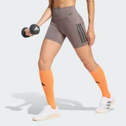 Krótkie legginsy Optime Workout 3-Stripes. Brązowe legginsy Adidas, bez wzorów, z lycry, z podwyższonym stanem, krótkie. Za 199.00 zł.