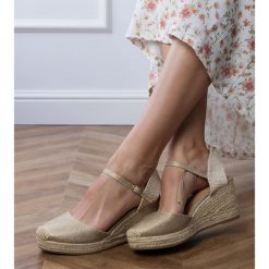 Złote sandały espadryle na koturnie złoty. Żółte sandały bez wzorów, ze skóry, eleganckie, z okrągłym noskiem, bez obcasa, na koturnie, bez zapięcia. Za 86.24 zł.