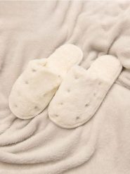 Kapcie - kremowy. Białe obuwie domowe Sinsay, bez wzorów, z futra, bez zapięcia. Za 19.99 zł.