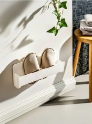 Ścienny uchwyt na kapcie - biały. Białe obuwie domowe Sinsay, bez wzorów, bez zapięcia. Za 15.99 zł.