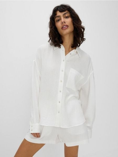 Koszula z bawełnianego muślinu - biały. Białe koszule Reserved, l, bez wzorów, z bawełny, bez kołnierzyka, bez ramiączek. W wyprzedaży za 99.99 zł.