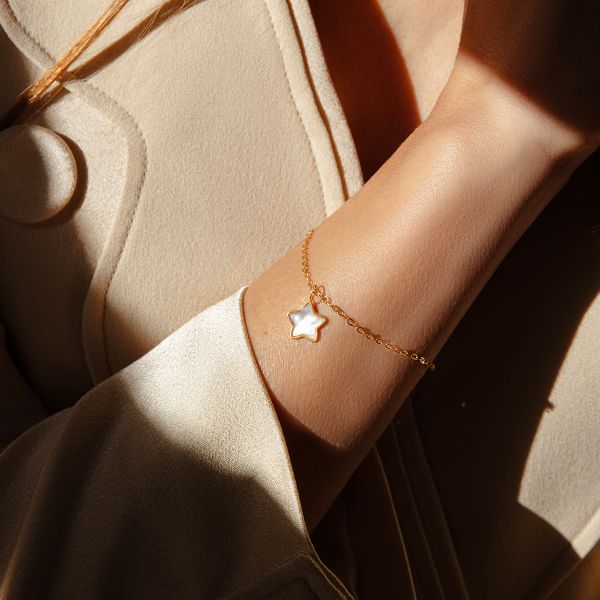 Bransoletka ze złota próby 585 z zawieszką gwiazdka z masy perłowej. Żółte bransoletki Lilou, z perłą, złote. Za 1,316.00 zł.