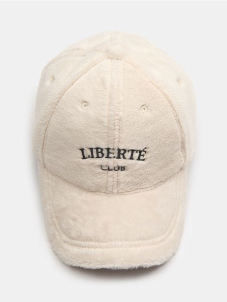 Czapka z daszkiem ze sztucznym futerkiem - kremowy. Białe czapki Sinsay, bez wzorów. Za 25.99 zł.